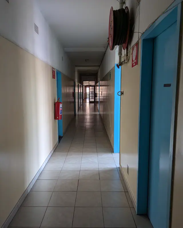 A long corridor of residents' rooms with blue doors