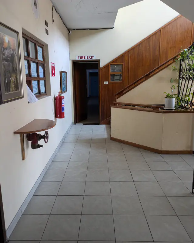 The hallway by the staircase, with framed pictures on the wall
