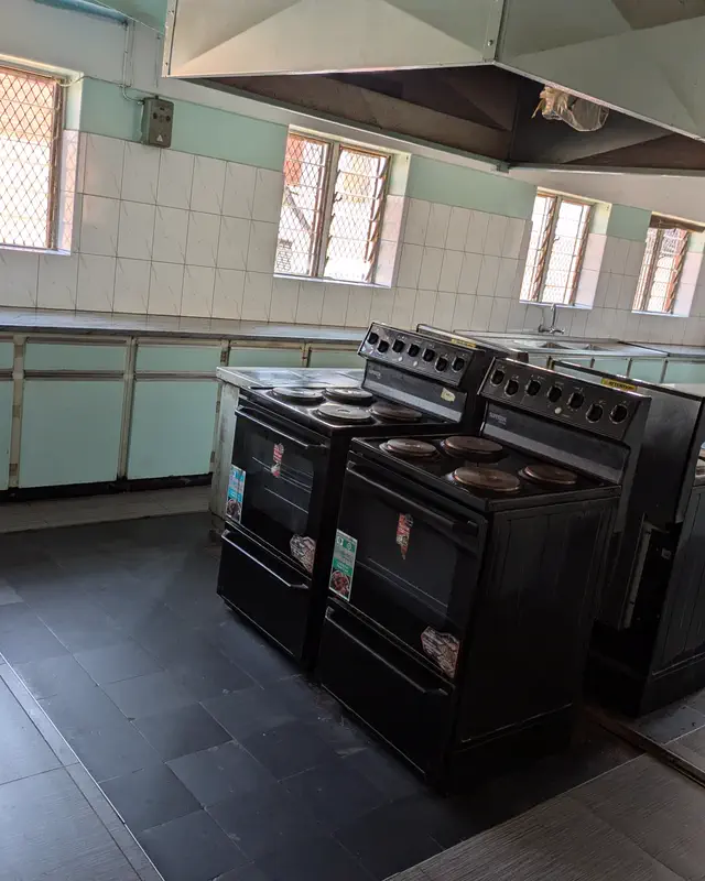 A shared kitchen with electric stoves and long counters